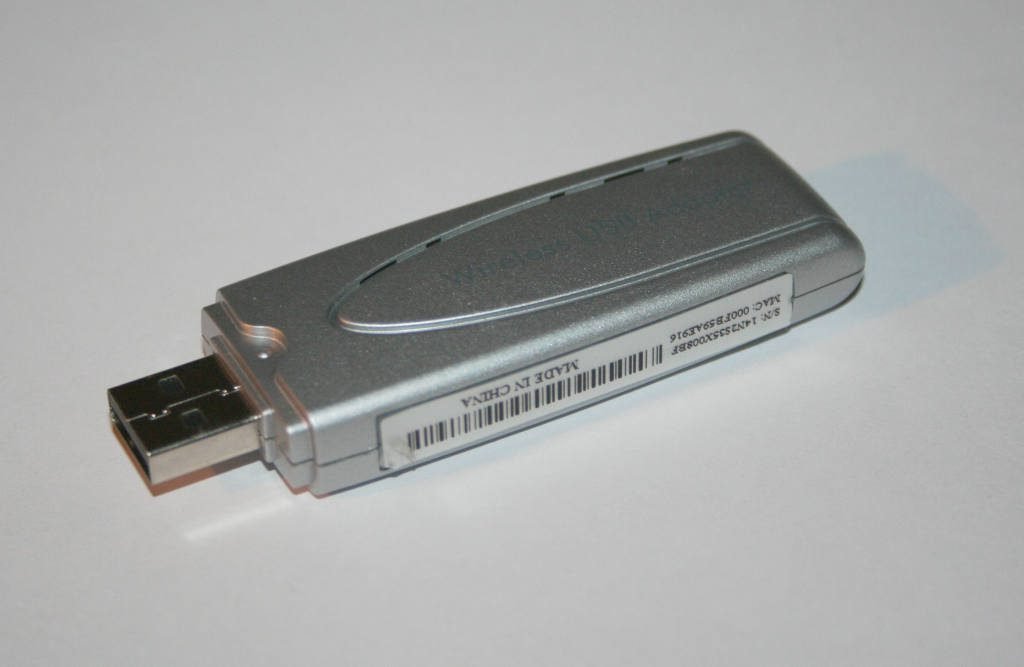 Adaptador de red Wi-Fi externo con conector USB y antena interna.